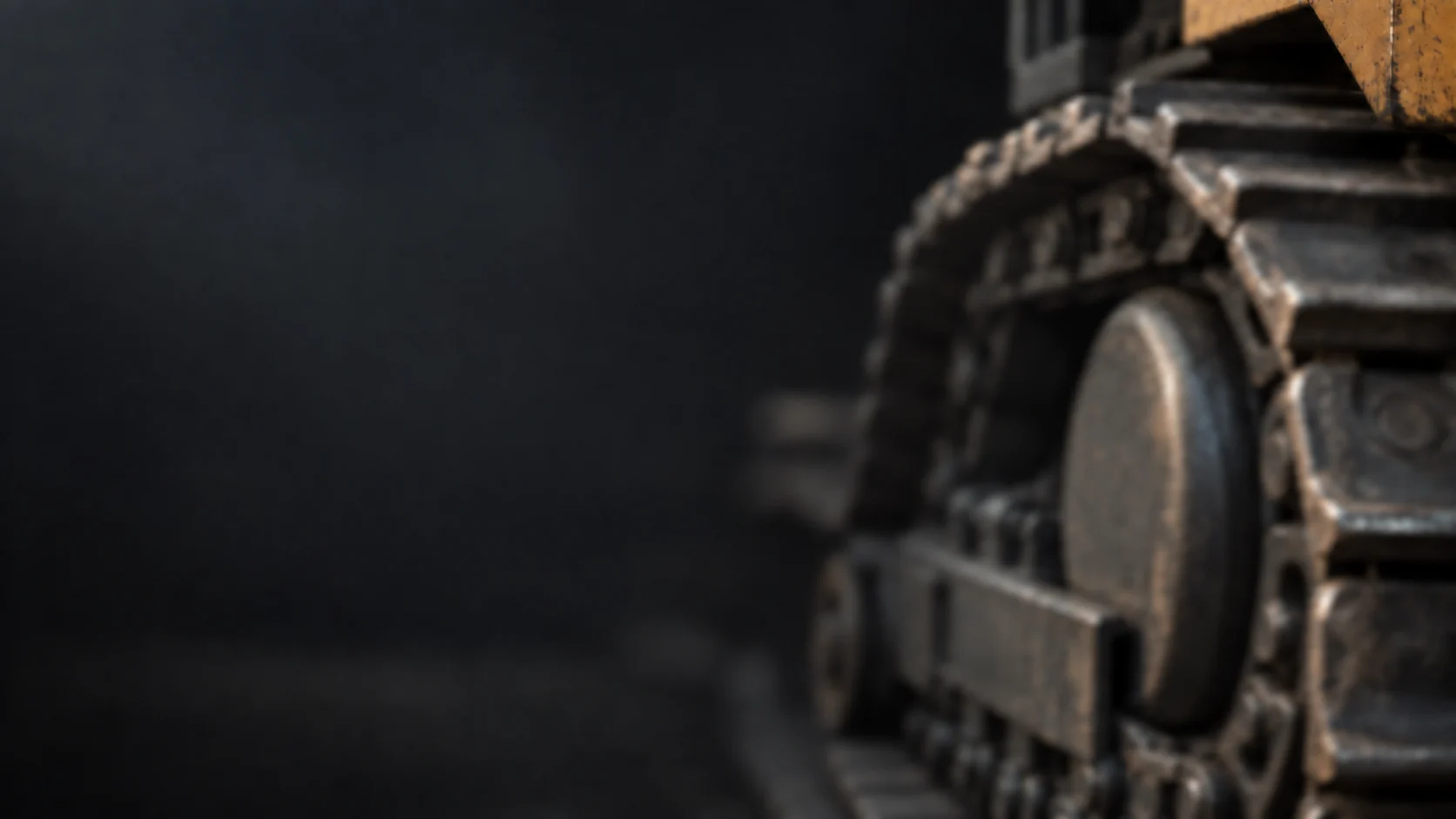 Illustrative close-up of a crawler undercarriage in soft charcoal shadows